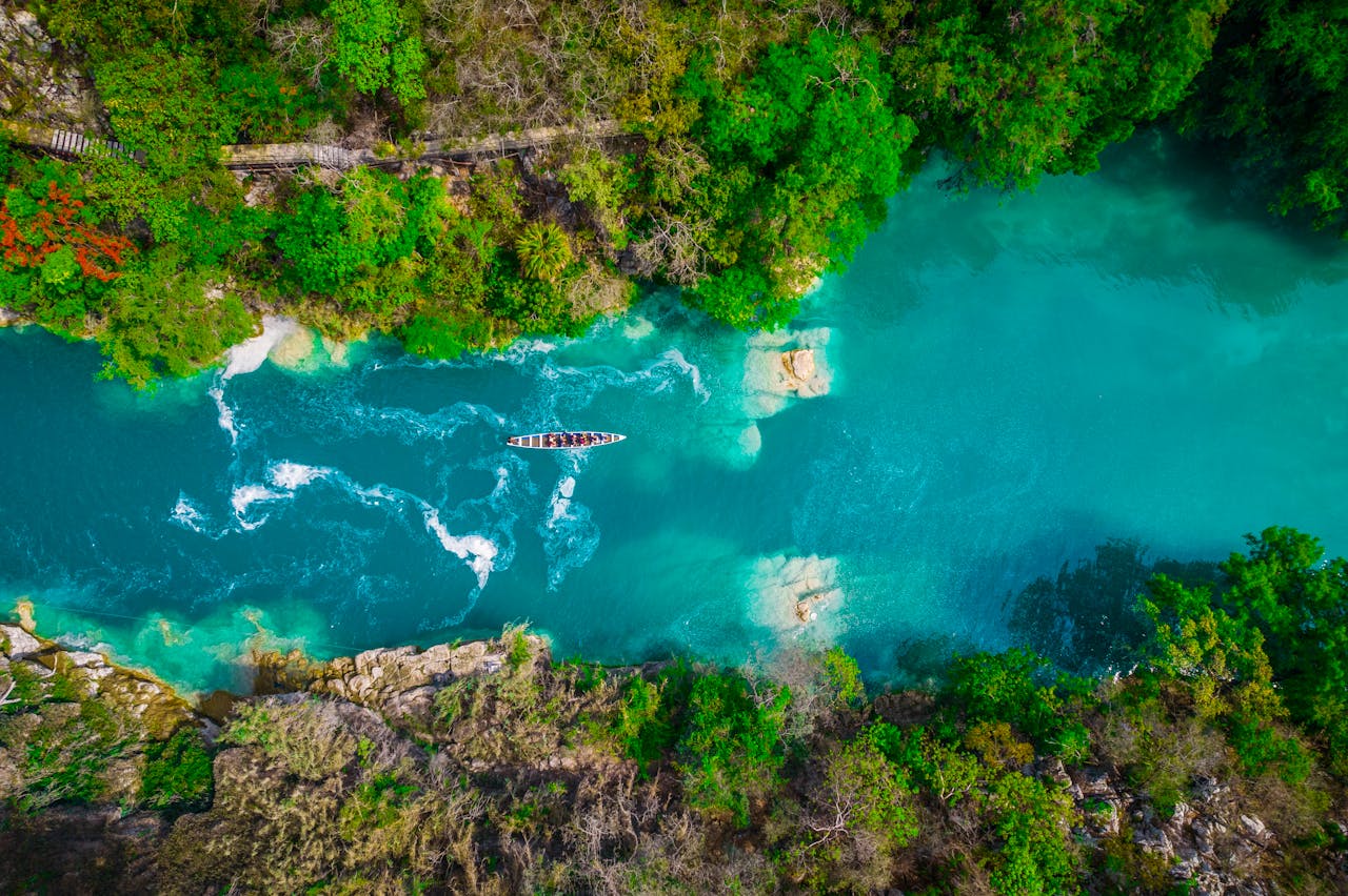 Stunning aerial view of a vibrant blue river flowing through lush forest in S.L.P., México.